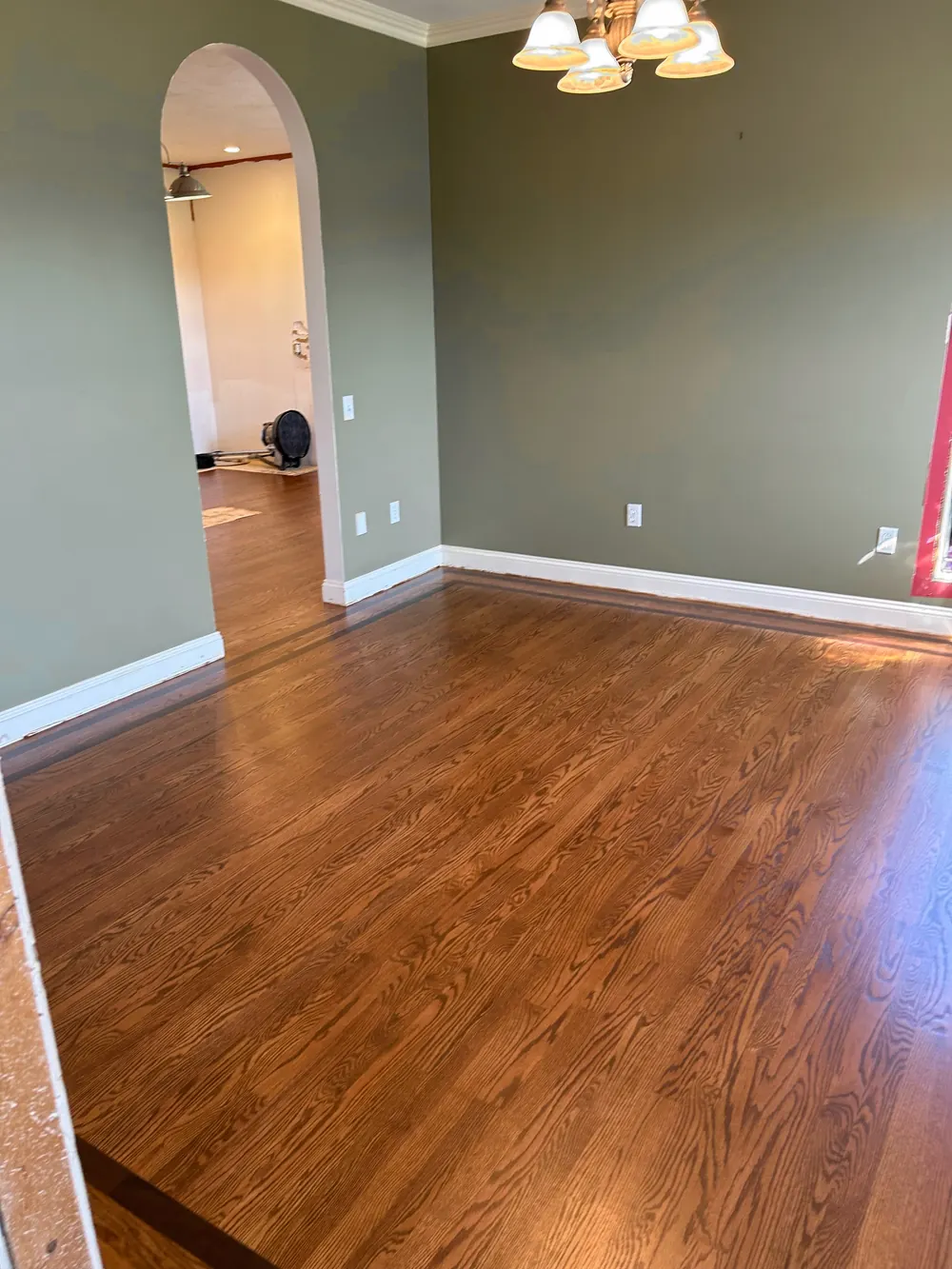 Dining room with a warm-stained oak floor and a darker border strip along the walls